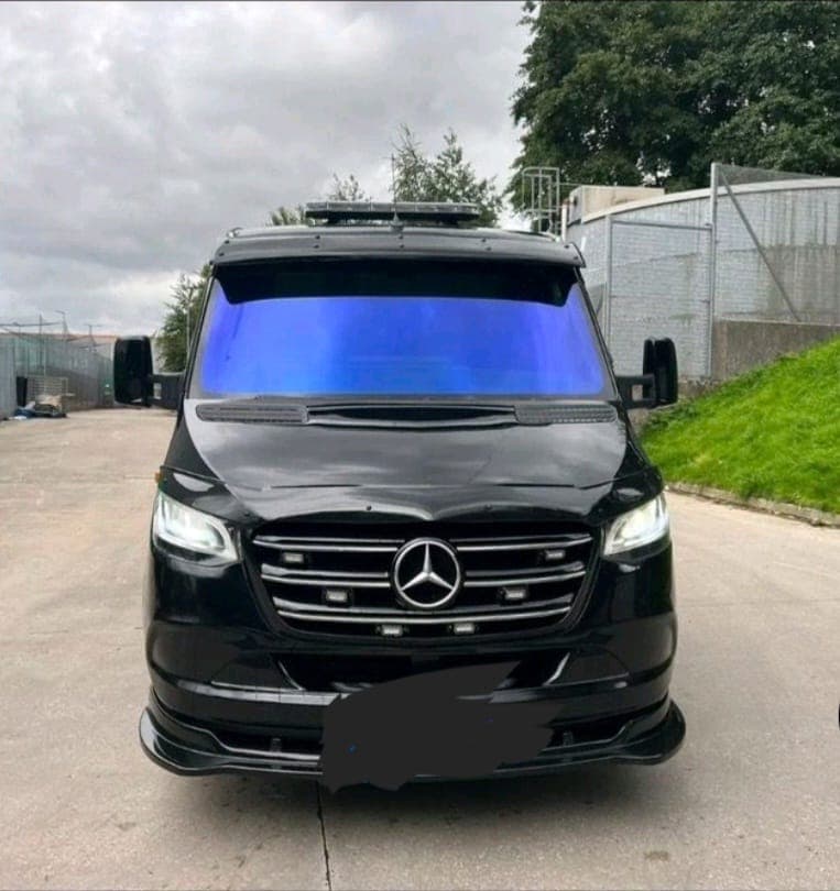 Front view of a blacked-out Mercedes-Benz Sprinter recovery van with custom LED lighting